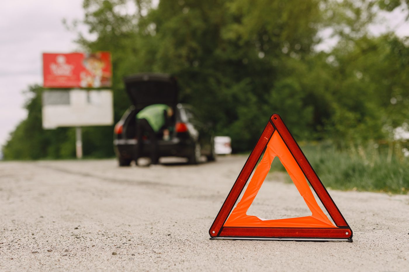 Triangolo di emergenza posizionato dietro un'auto in panne a bordo strada