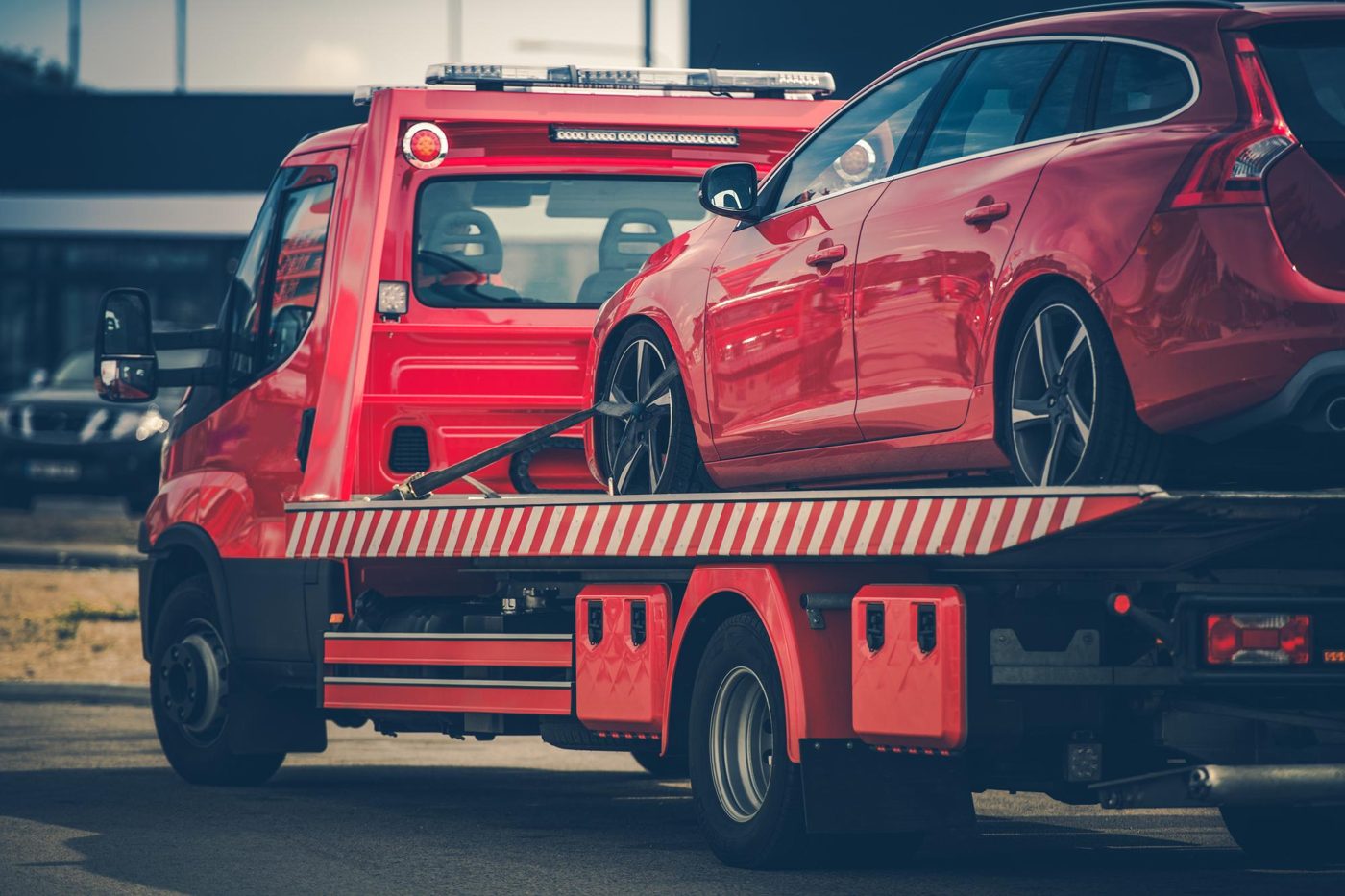 Carroattrezzi rosso con auto rossa fissata sul pianale