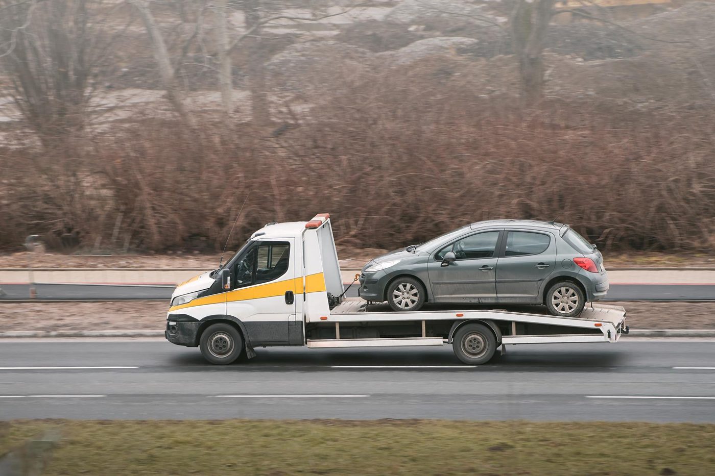 Traino di un'auto in panne su carroattrezzi a pianale